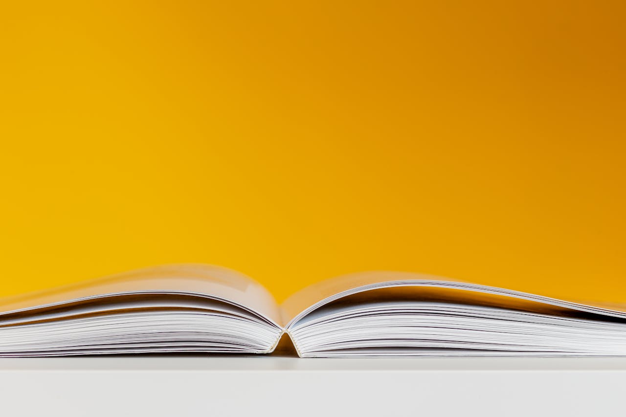 creative A close-up shot of an open book with a vivid yellow background, perfect for creative and conceptual design.